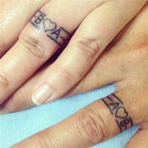 tattoo initials on ring finger|ring finger tattoos for married couples.